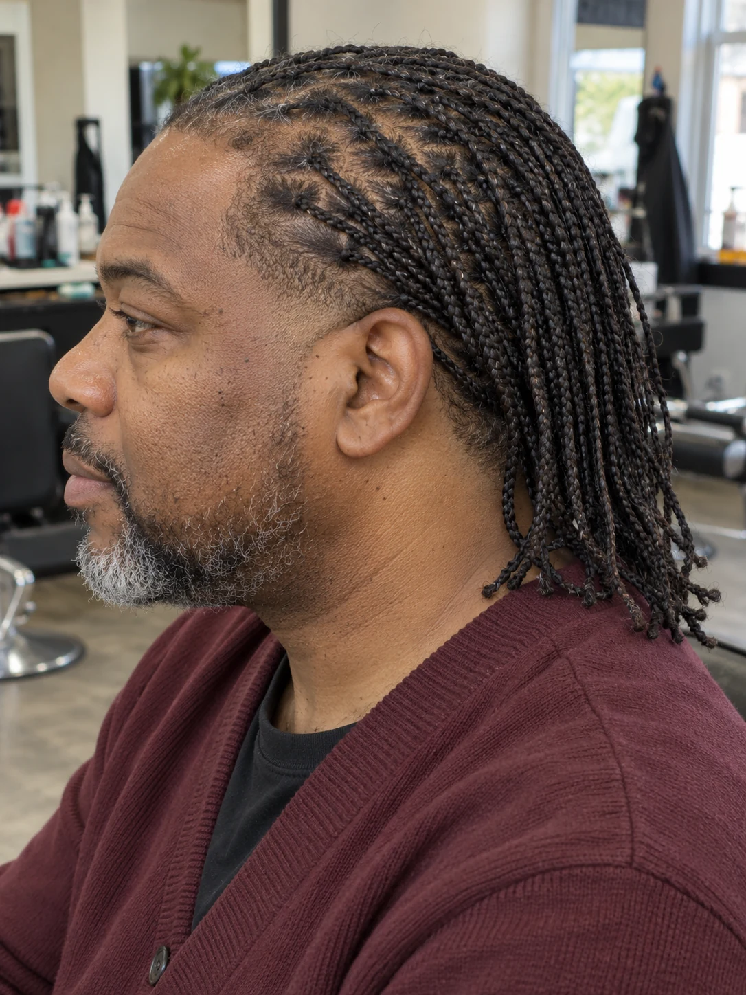 AI haircut concept: low taper with loose microbraids, left-side angled view.