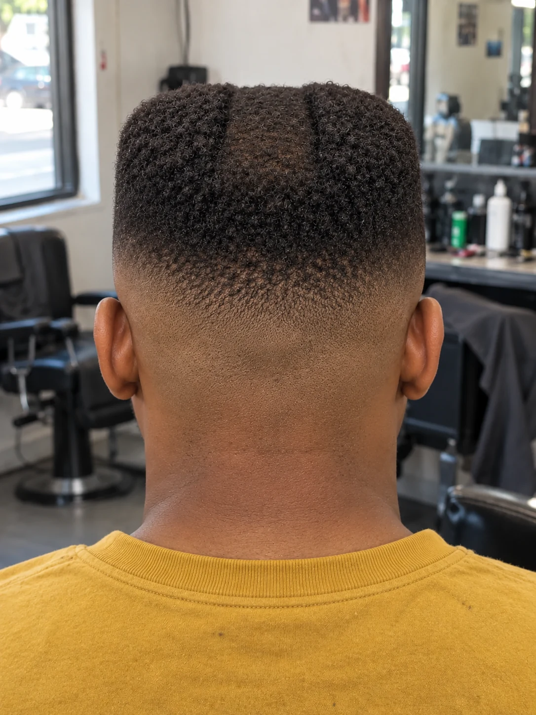 AI haircut concept: high skin fade with a recessed-centre flat top, rear view.